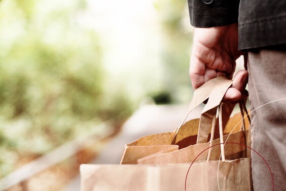 Eine Person trägt mehrere Papiertüten