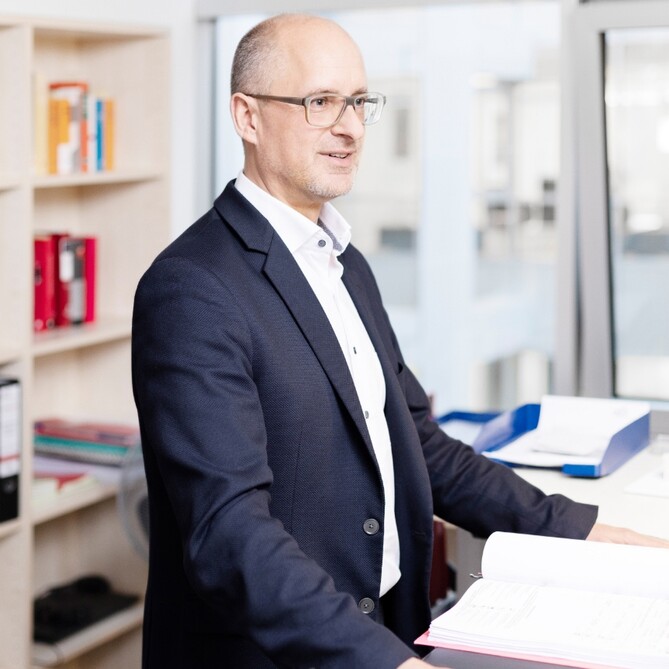 Thomas Bertram steht am Schreibtisch